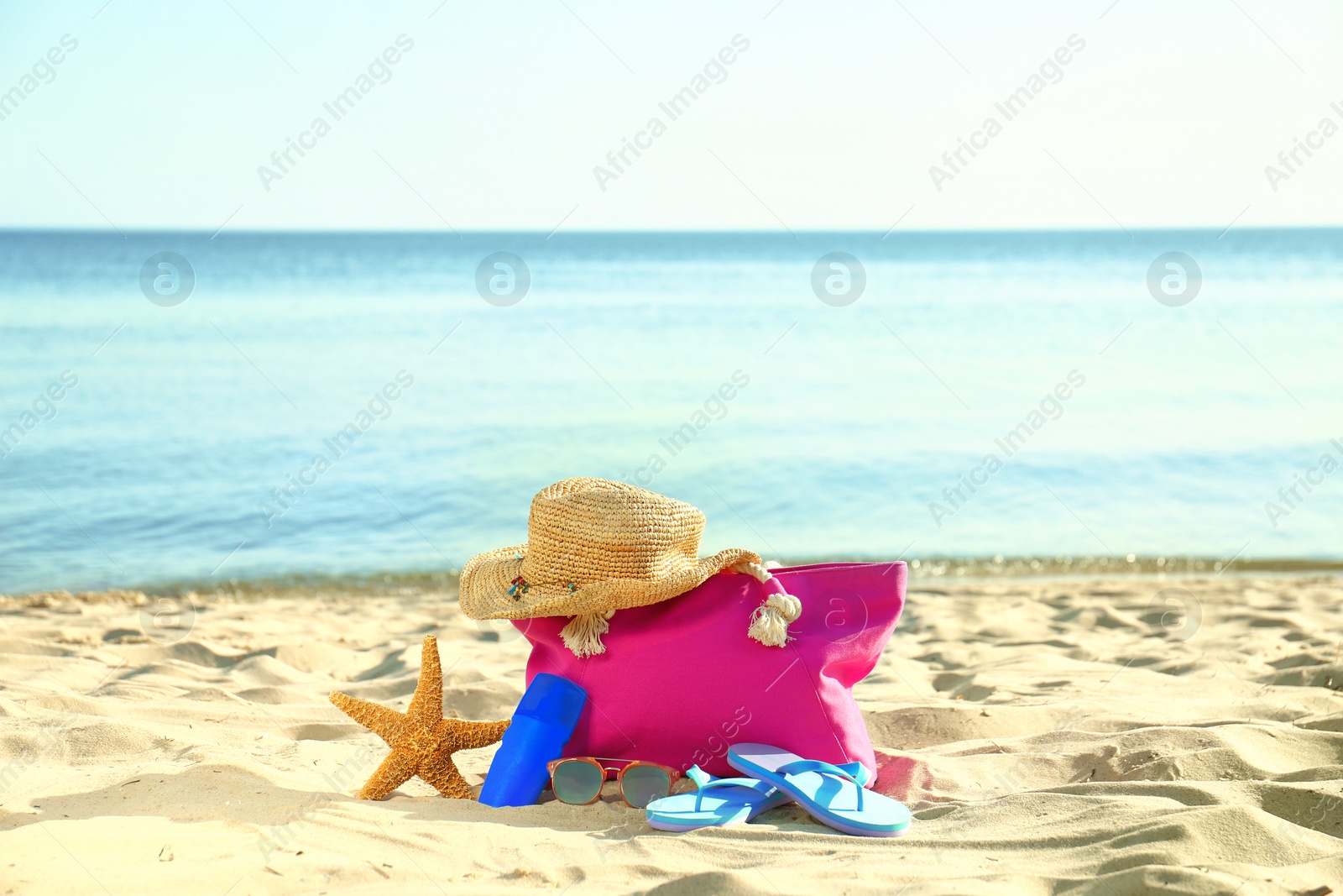 Photo of Composition with stylish beach accessories on sand near sea