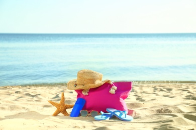 Photo of Composition with stylish beach accessories on sand near sea