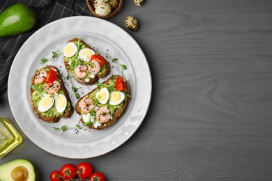 Delicious sandwiches with guacamole, shrimps and eggs on wooden table, flat lay. Space for text