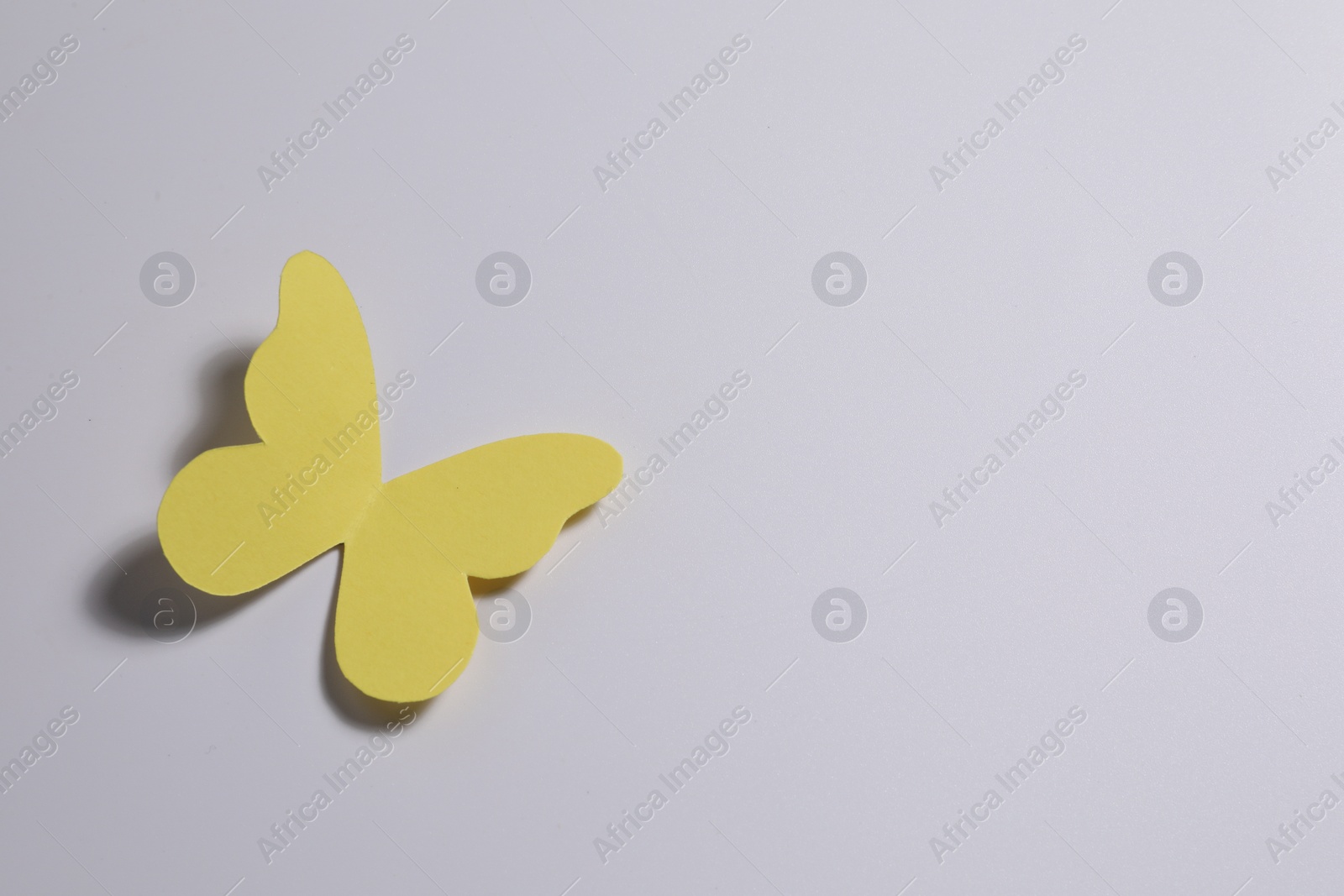 Photo of Yellow paper butterfly on light background, top view. Space for text