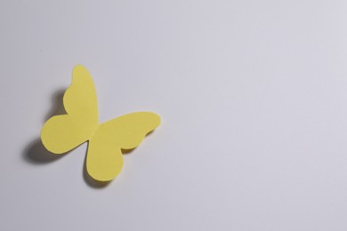 Yellow paper butterfly on light background, top view. Space for text