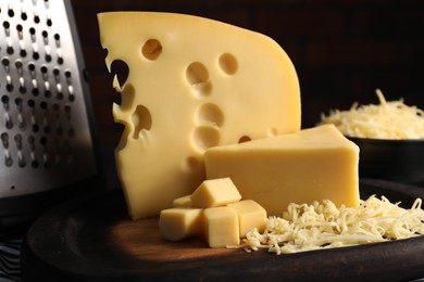 Photo of Grated and cut cheese on table, closeup