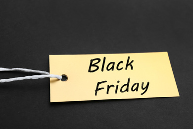 Golden blank tag on dark background, closeup. Black Friday concept