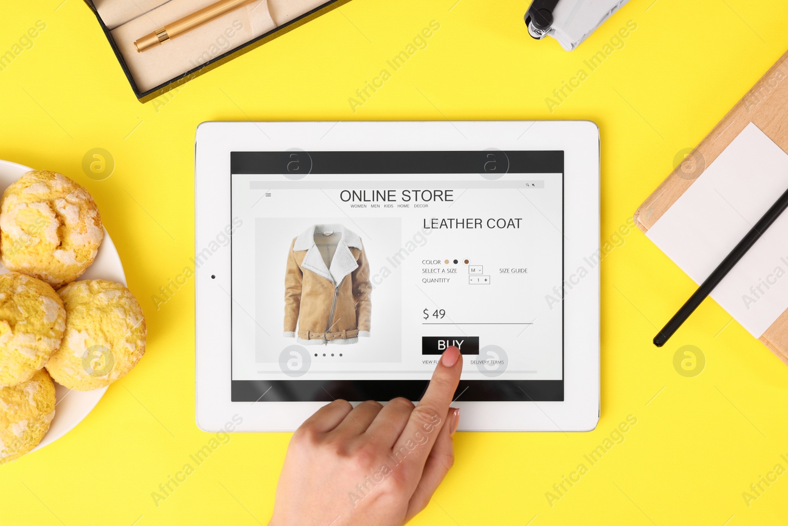 Photo of Woman with tablet shopping online on yellow background, top view