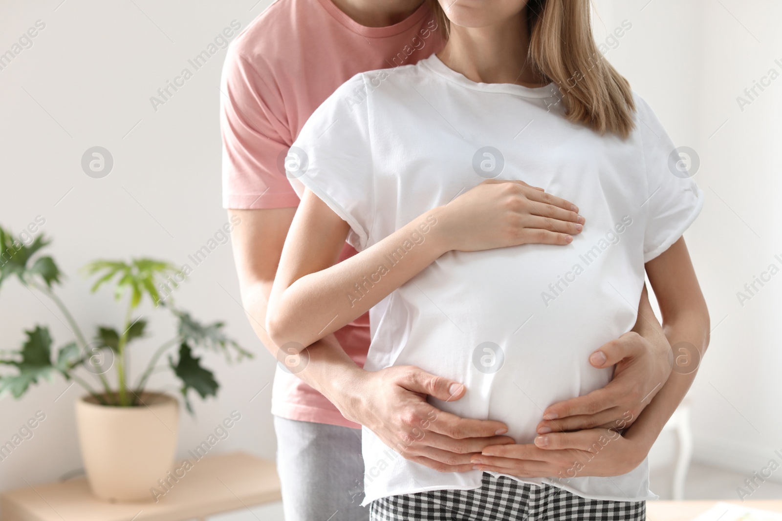 Photo of Young pregnant woman with her husband at home