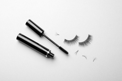 Photo of False eyelashes and mascara on white background, top view