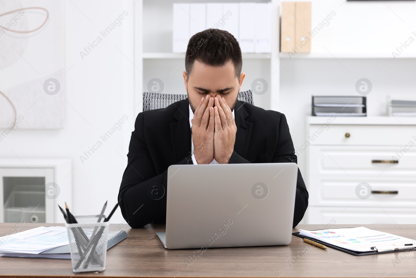 Photo of Sick man coughing at workplace in office