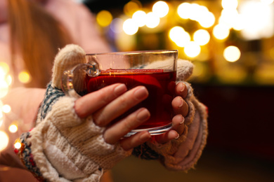 Woman with mulled wine at winter fair, closeup