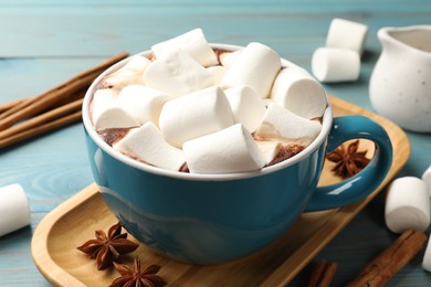 Photo of Tasty hot chocolate with marshmallows on light blue wooden table, closeup