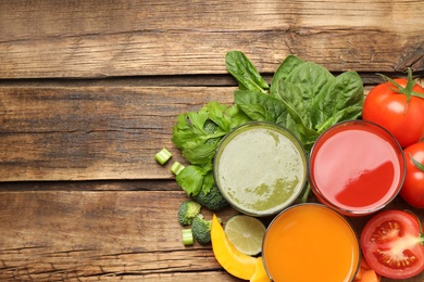 Photo of Delicious vegetable juices and fresh ingredients on wooden table, flat lay. Space for text