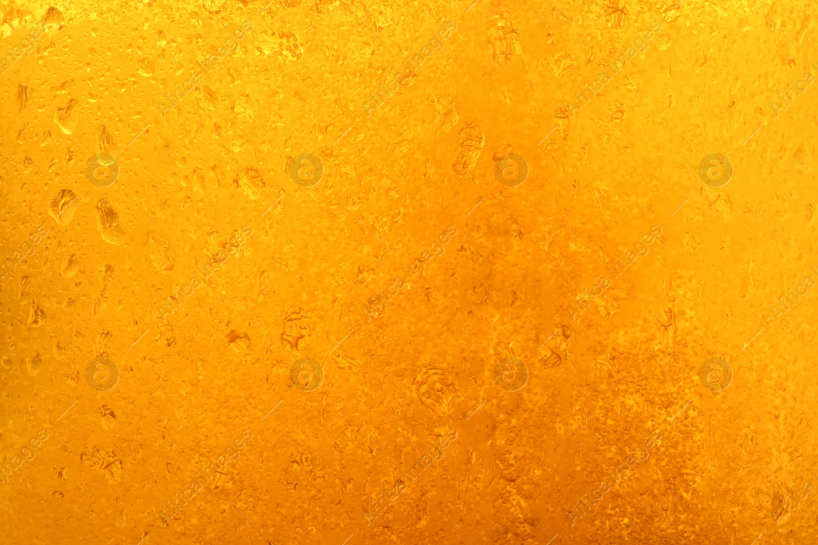 Photo of Glass of tasty cold beer with condensation drops as background, closeup