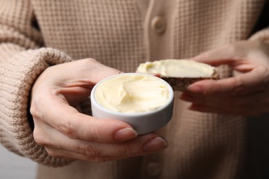 Woman holding slice of bread and butter, closeup