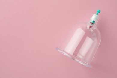 Plastic cup on pink background, top view with space for text. Cupping therapy