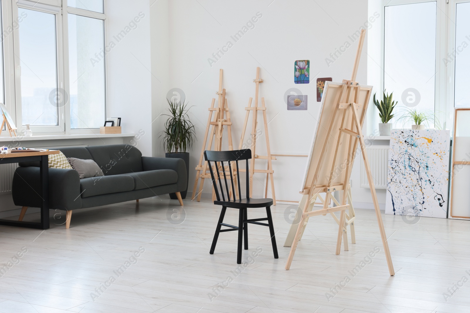 Photo of Studio with easels, chair and sofa. Artist`s workspace