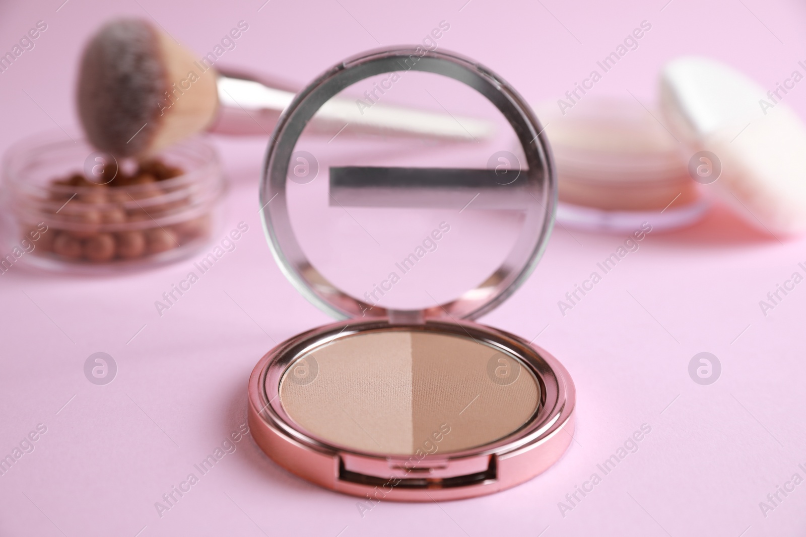 Photo of Face powder on pink background, closeup. Cosmetic products