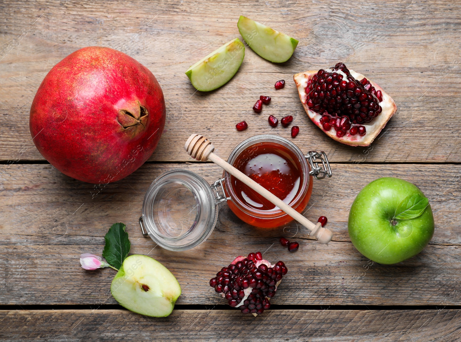 Photo of Honey, pomegranate and apples on wooden table, flat lay. Rosh Hashana holiday