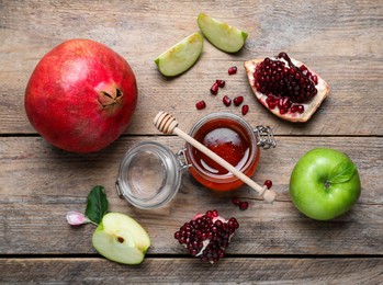 Honey, pomegranate and apples on wooden table, flat lay. Rosh Hashana holiday