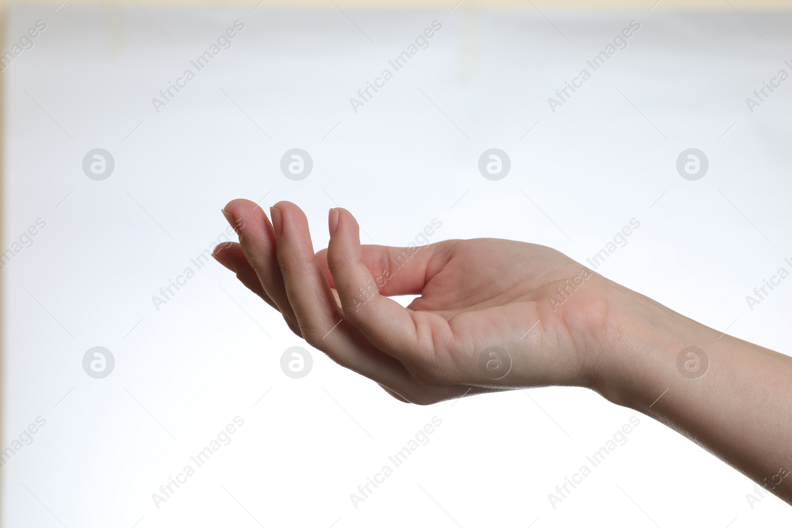 Photo of Woman holding something in hand on white background, closeup