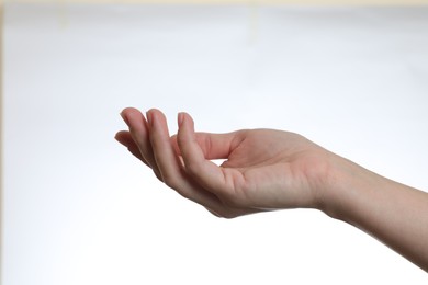 Photo of Woman holding something in hand on white background, closeup