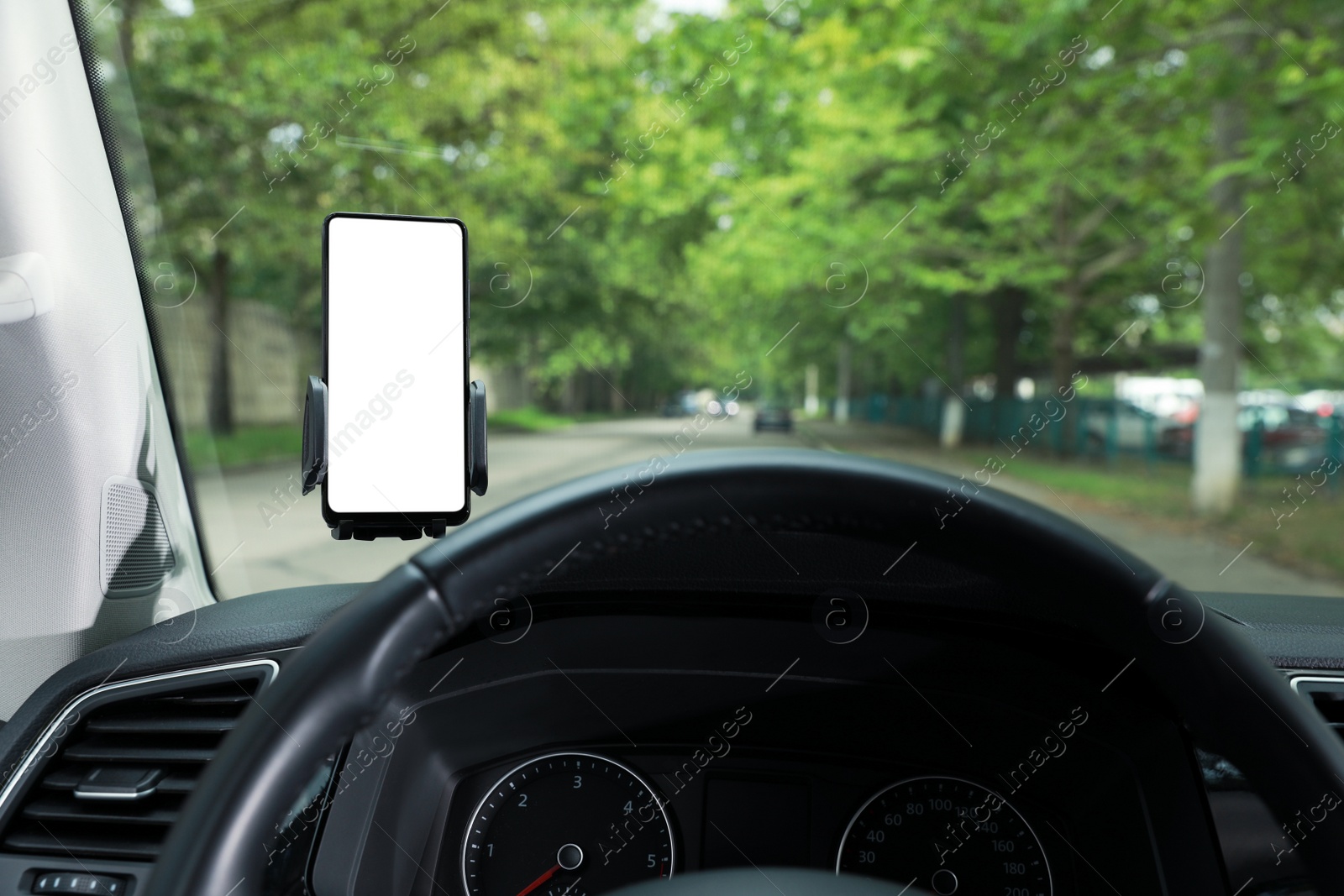 Photo of Car holder with modern mobile phone on windshield of automobile. Mockup for design