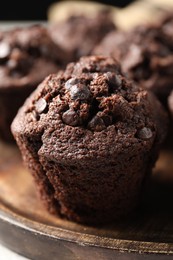 Photo of Board with delicious chocolate muffin on table, closeup