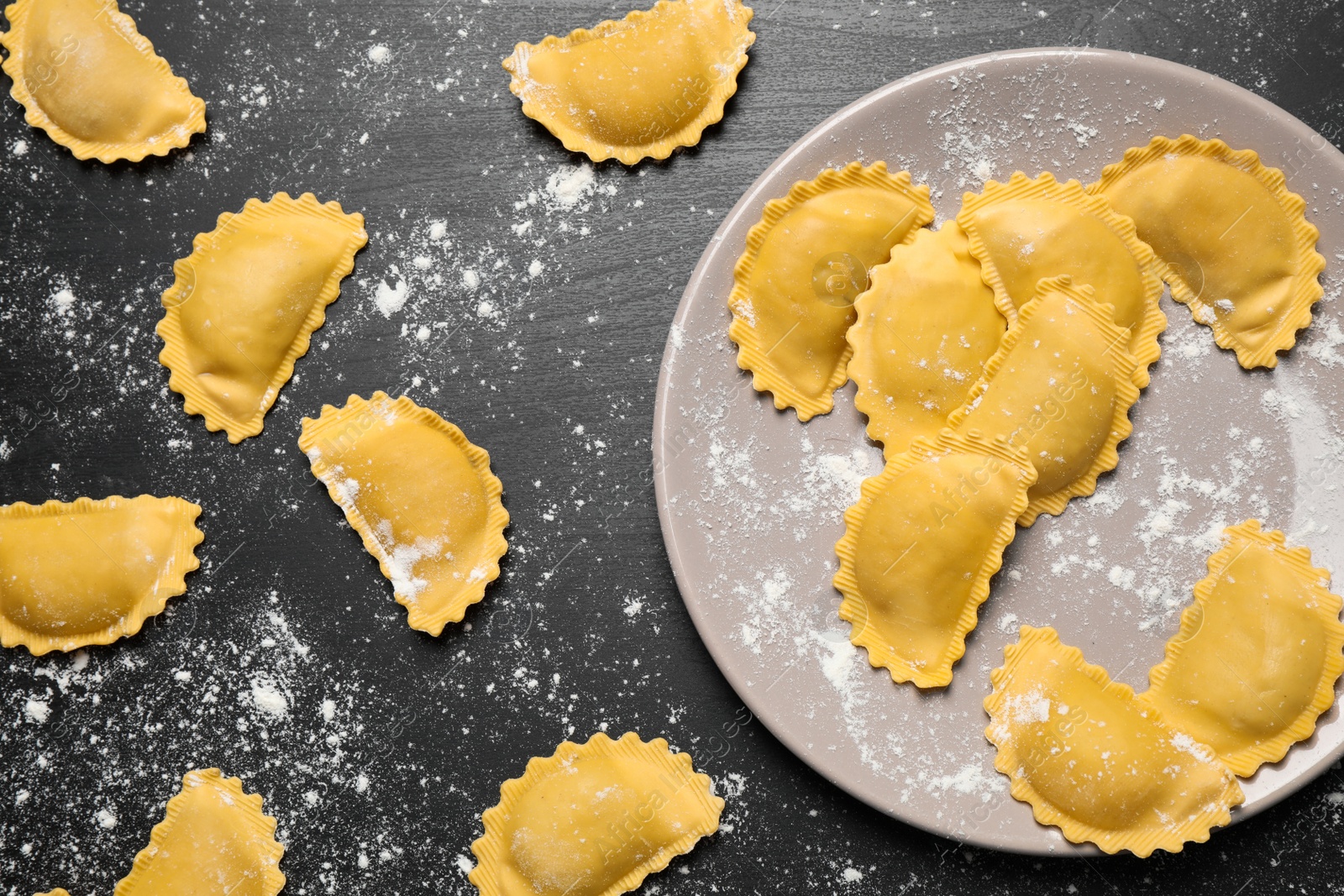 Photo of Ravioli on grey wooden table, flat lay. Italian pasta