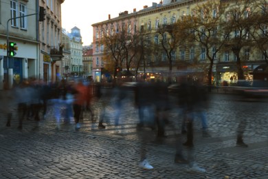 Blurred view of people crossing street in city