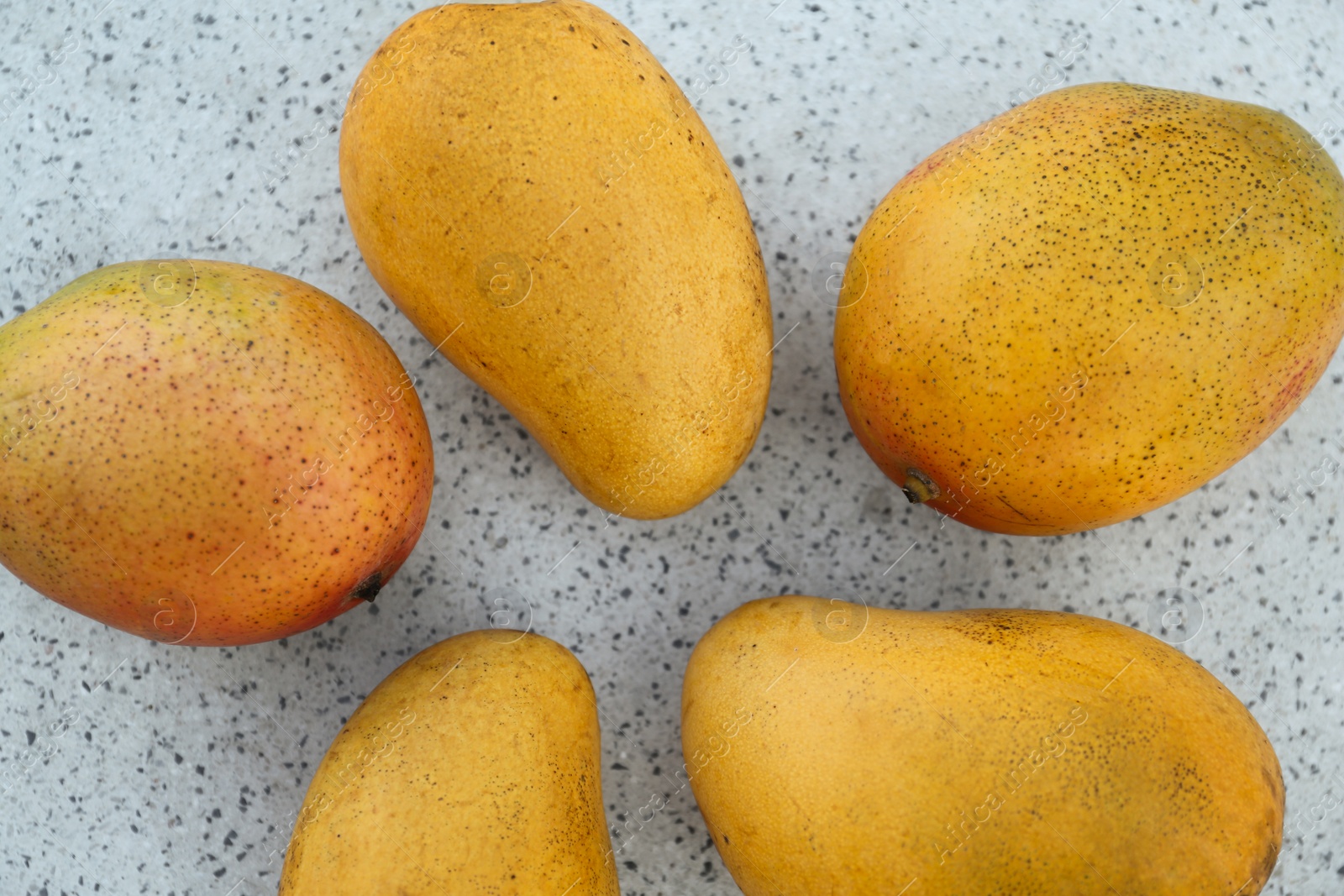 Photo of Delicious ripe juicy mangos on table, flat lay