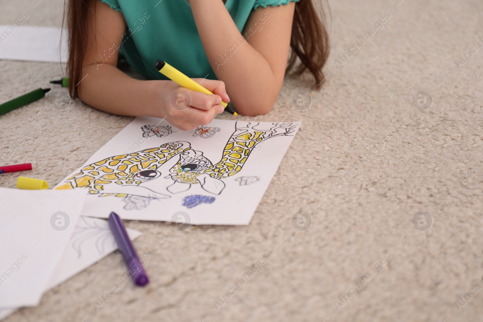 Photo of Child coloring drawing on floor at home, closeup. Space for text