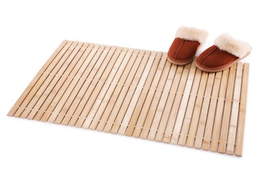 Photo of Bamboo rug with soft slippers isolated on white. Bath accessory