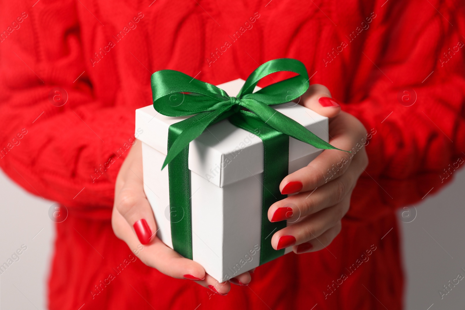 Photo of Christmas present. Woman holding gift box, closeup