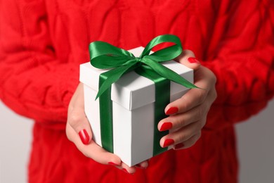 Photo of Christmas present. Woman holding gift box, closeup