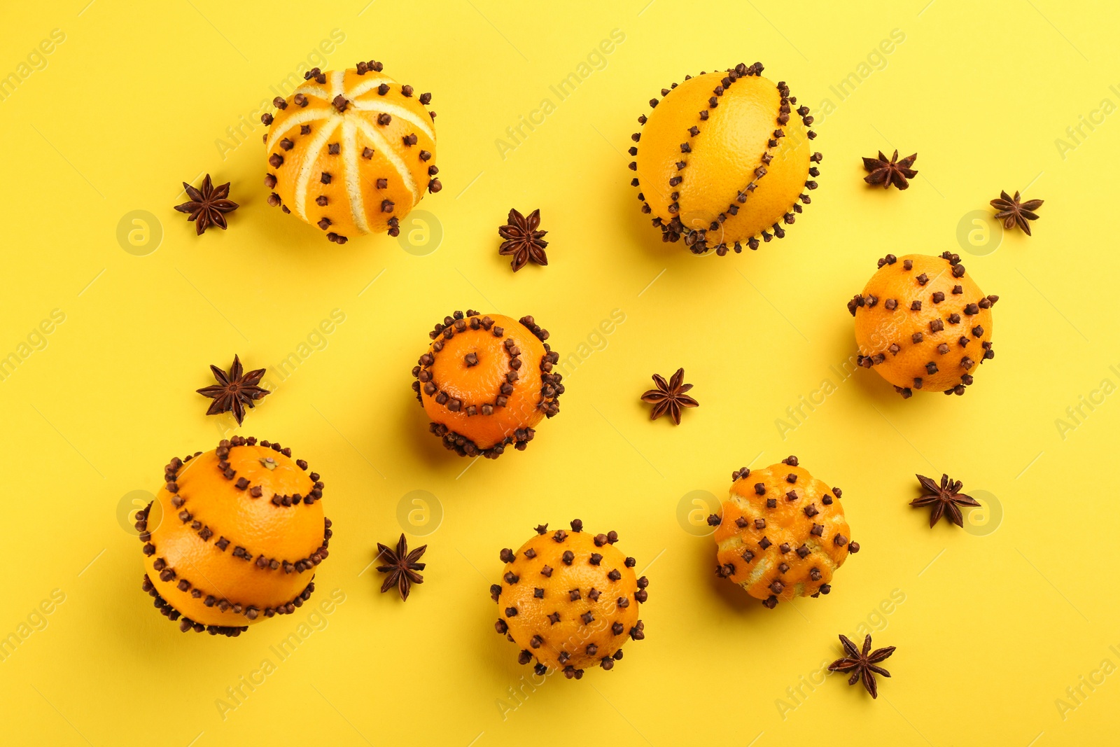 Photo of Flat lay composition with pomander balls made of fresh tangerines and oranges on yellow background
