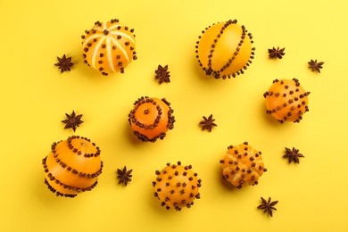 Photo of Flat lay composition with pomander balls made of fresh tangerines and oranges on yellow background