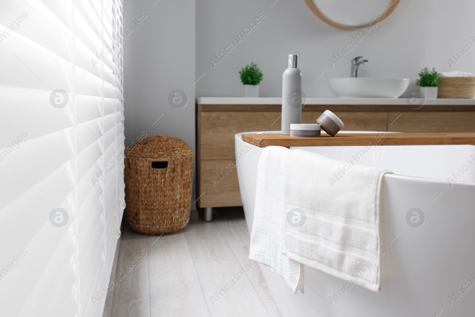 Photo of Fresh white towels on tub in bathroom. Space for text