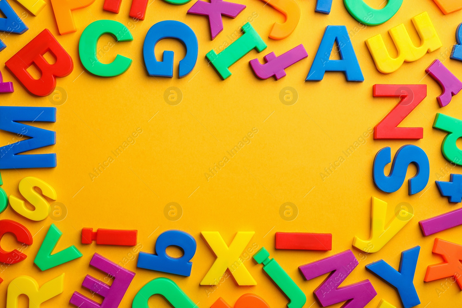 Photo of Frame made of plastic magnetic letters on color background, top view with space for text