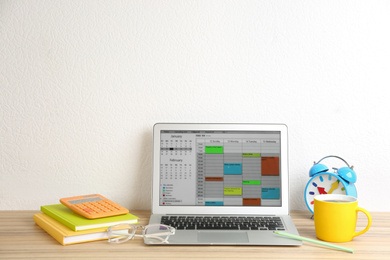 Photo of Modern laptop with calendar app in office