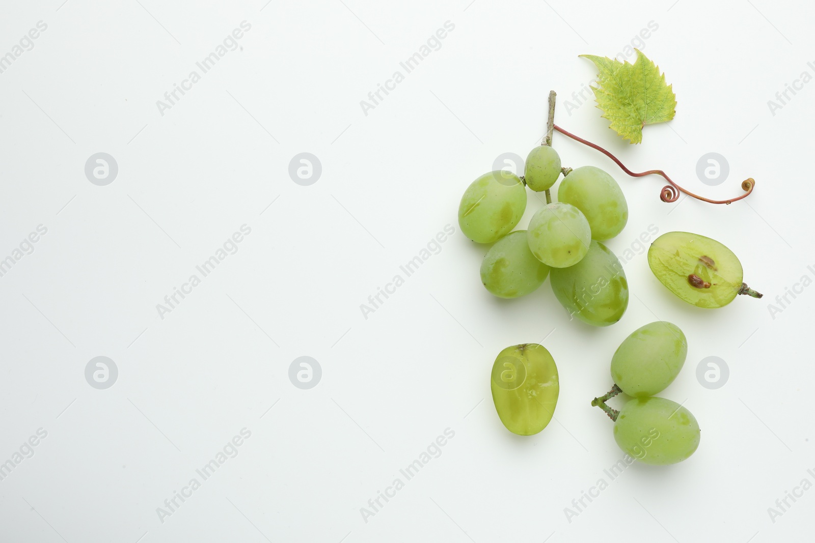 Photo of Fresh grapes and leaf on white background, top view. Space for text
