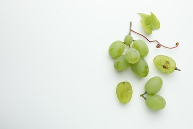 Fresh grapes and leaf on white background, top view. Space for text