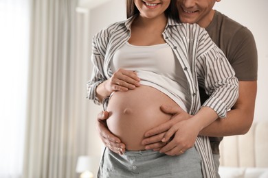 Young pregnant woman with her husband at home, closeup