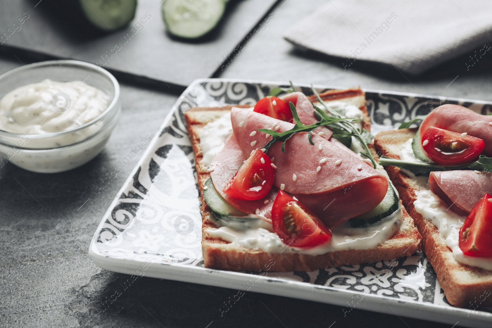 Image of Tasty sandwiches with ham served on grey table, closeup. Food photography  