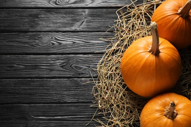 Photo of Ripe pumpkins on wooden background, flat lay with space for text. Holiday decoration