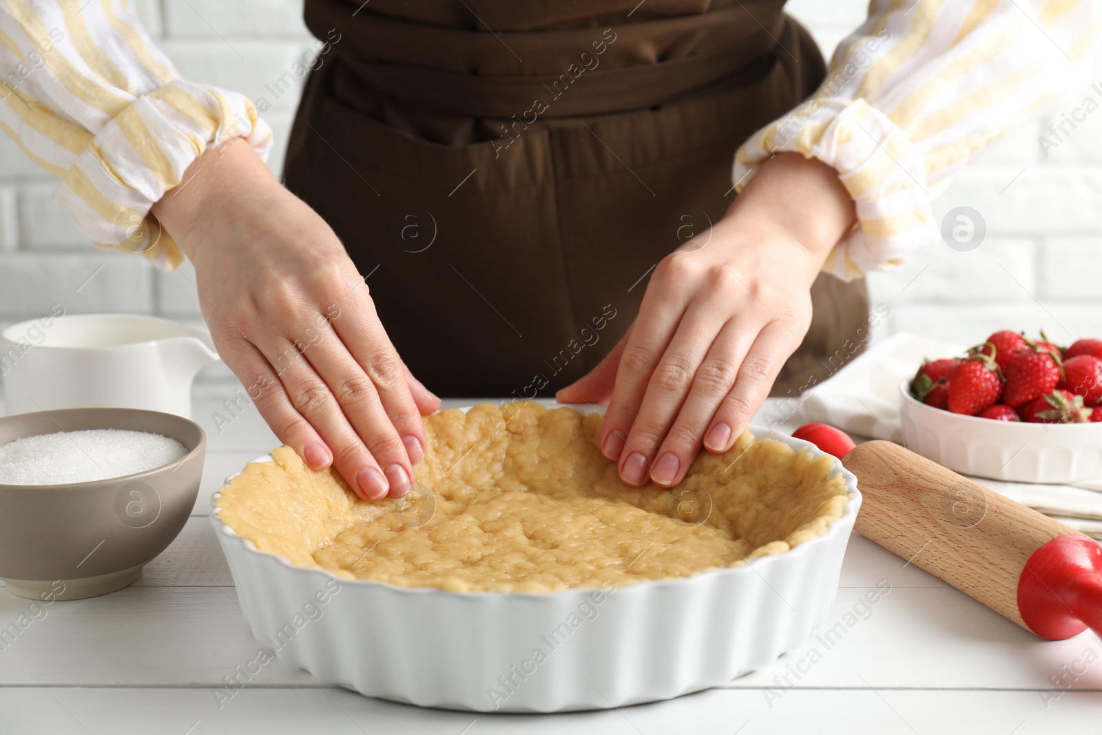 Photo of Shortcrust pastry. Woman making pie at white wooden table, closeup