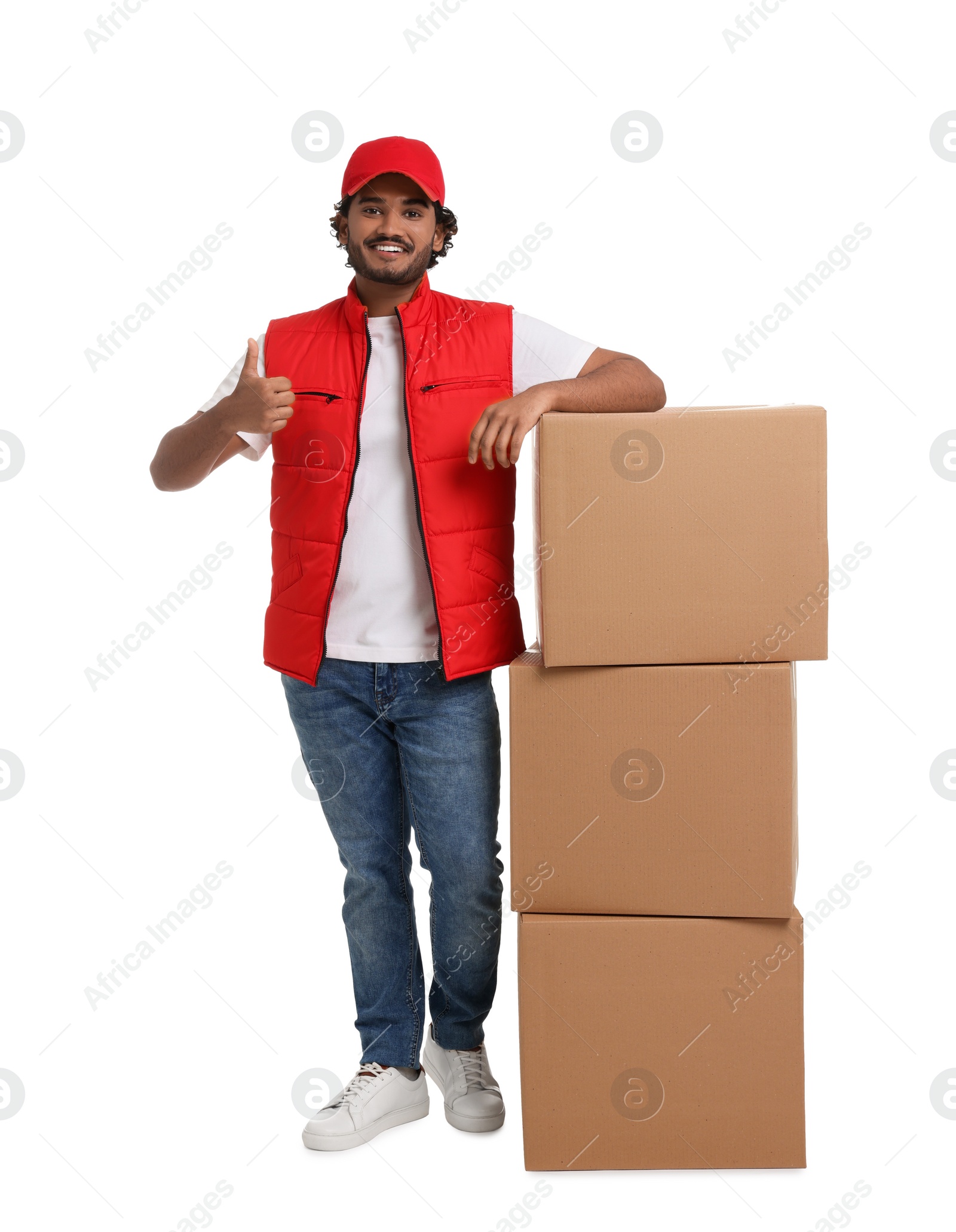 Photo of Happy courier with stack of parcels showing thumb up on white background