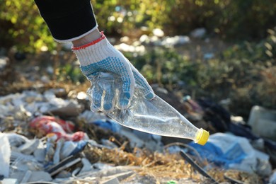 Photo of Woman picking up plastic garbage outdoors, closeup