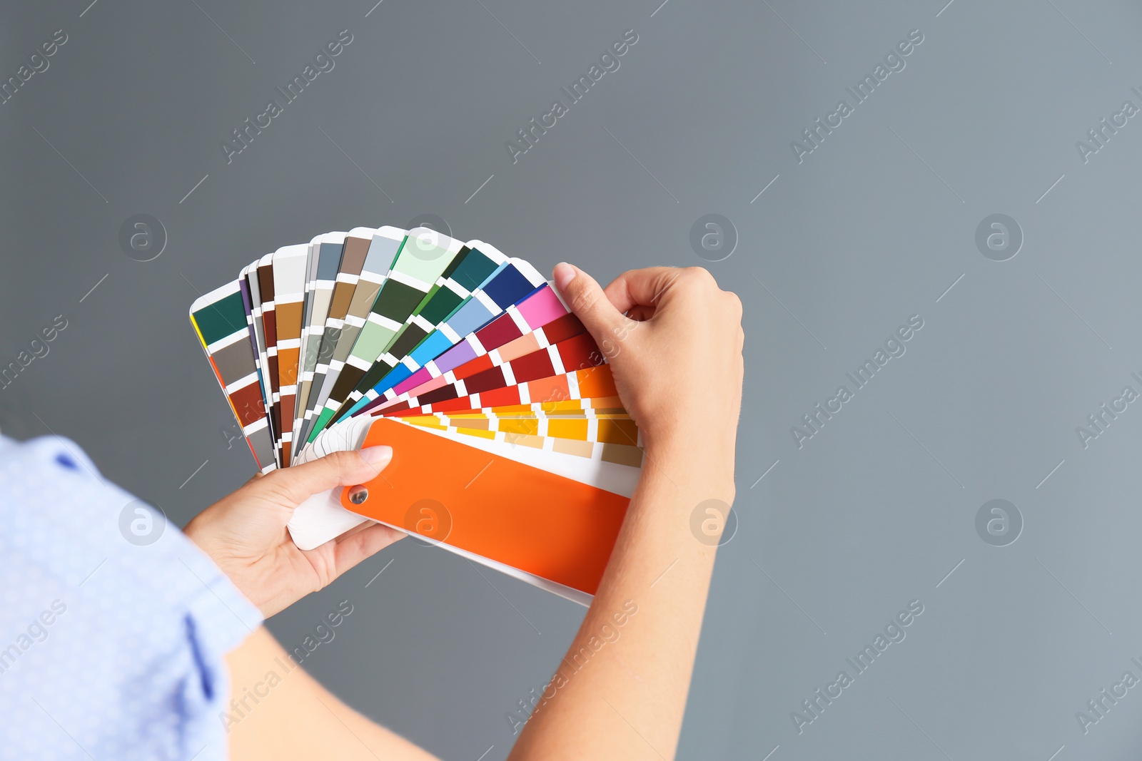 Photo of Female interior designer with palette samples on color background, closeup. Space for text