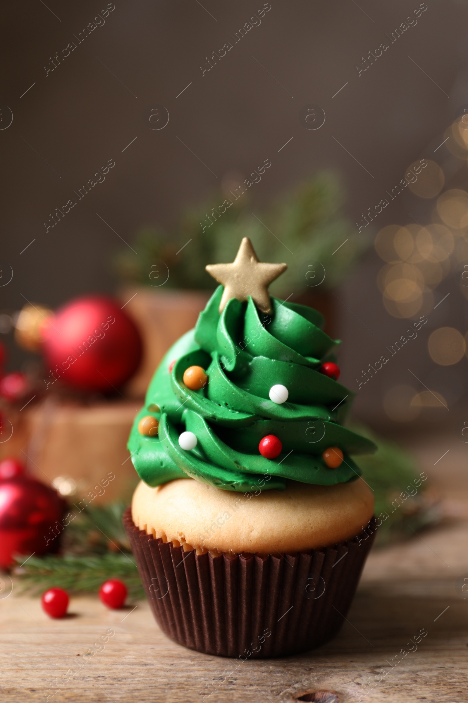 Photo of Christmas tree shaped cupcake on wooden table