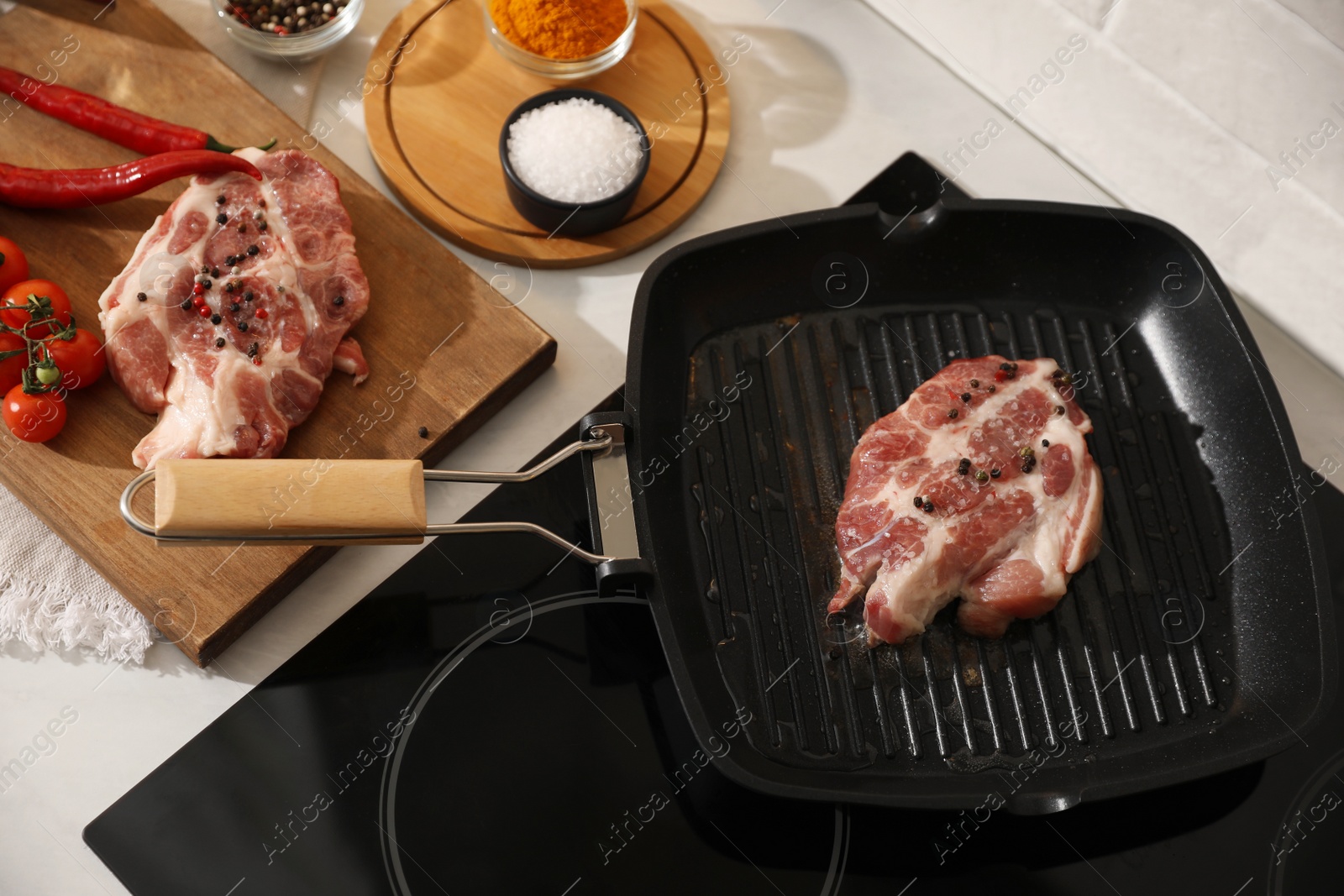 Photo of Frying pan with fresh raw meat on stove, above view