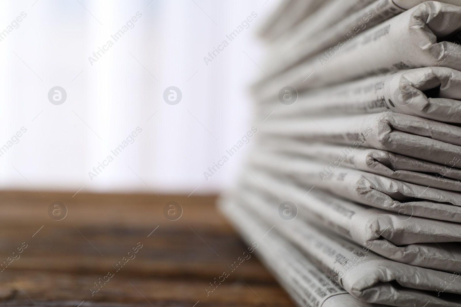 Photo of Stack of newspapers on wooden table, space for text. Journalist's work