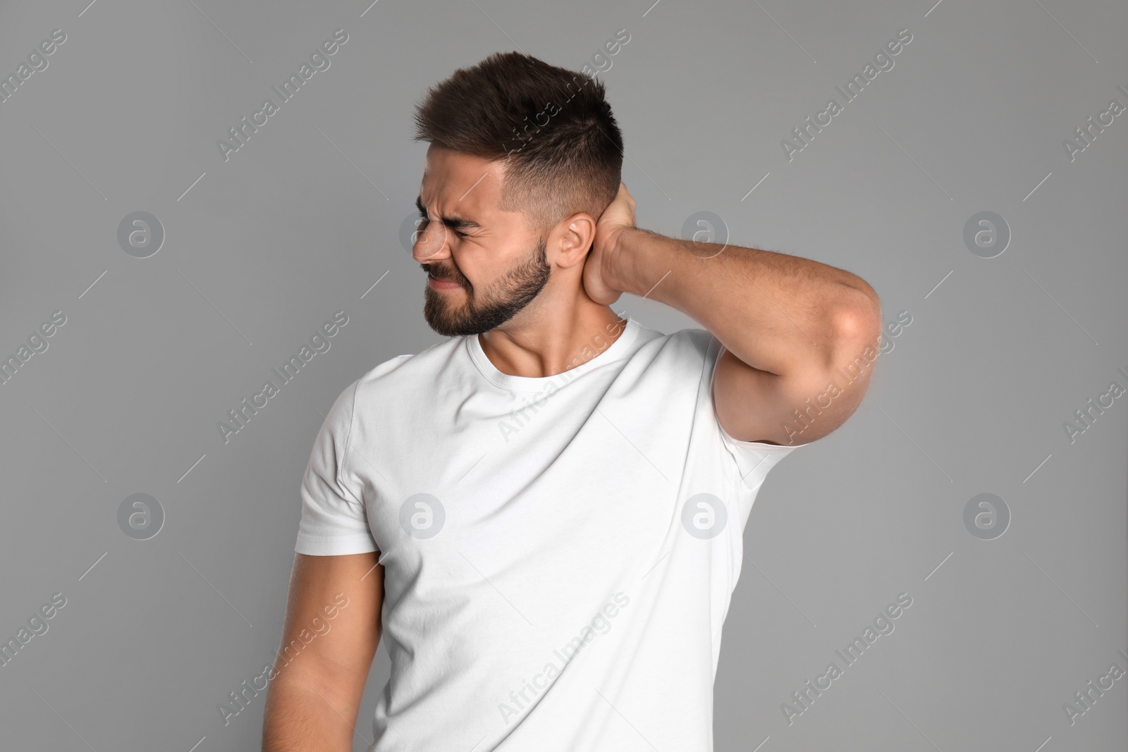 Photo of Man suffering from headache on light grey background